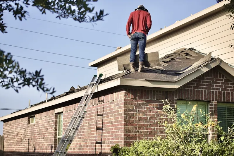 Professional roofer working on a residential roof in New Hudson